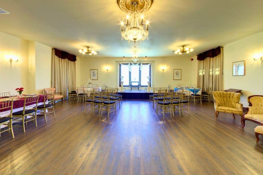 Elegant event space with chandeliers and arranged seating.