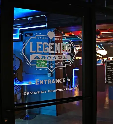 Entrance door of Legends Arcade in downtown Olympia, WA, featuring illuminated signage.
