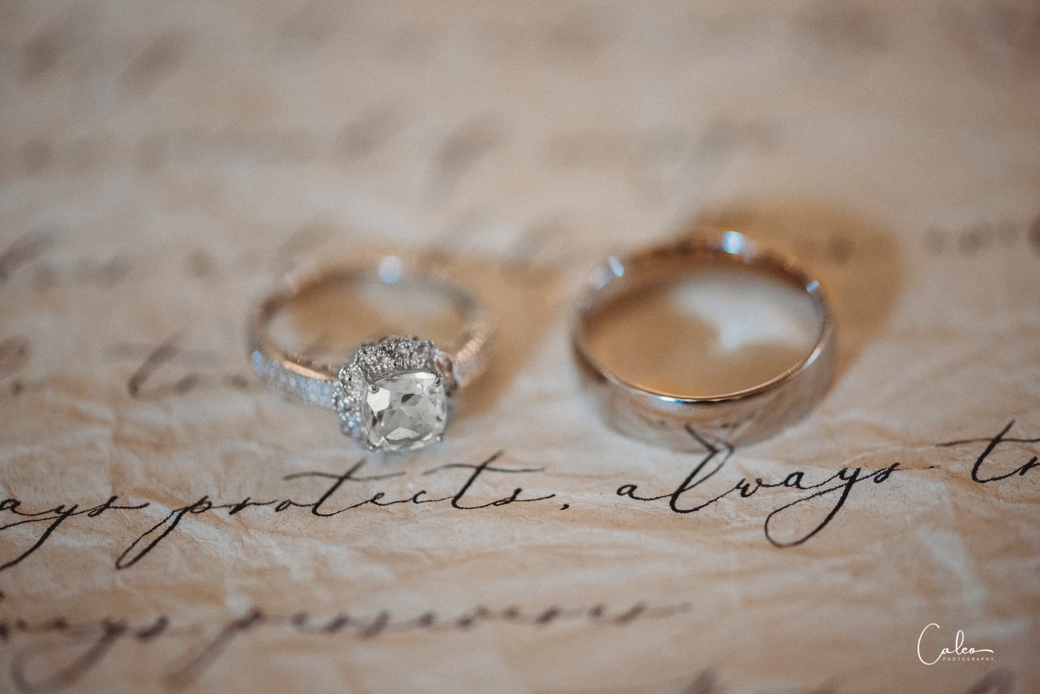 Wedding rings placed on handwritten paper with elegant script.